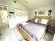 Bright bedroom with white tiled floor, double closet, and wood-trimmed bed at 2560 Woodgate Blvd # 203, Orlando, FL 32822