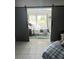 Bedroom with view through the sliding barn doors to bed and an outdoor balcony at 2560 Woodgate Blvd # 203, Orlando, FL 32822