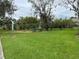 Well maintained dog park with green grass, mature trees, picnic bench, and dog waste station at 2560 Woodgate Blvd # 203, Orlando, FL 32822