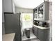 Bright kitchen featuring gray cabinetry, stainless steel refrigerator, and lots of storage by the window at 2560 Woodgate Blvd # 203, Orlando, FL 32822