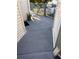 Exterior walkway with modern gray finish, surrounded by white siding and railing at 2560 Woodgate Blvd # 203, Orlando, FL 32822