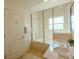 Bright bathroom featuring a double sink vanity and a glass enclosed tub and shower at 2652 Corvette Ln, Kissimmee, FL 34746