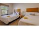 Cozy bedroom with two beds, a nightstand, and a sunlit window at 2652 Corvette Ln, Kissimmee, FL 34746