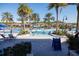 Spacious community pool surrounded by palm trees, lounge chairs, and lush landscaping at 2652 Corvette Ln, Kissimmee, FL 34746