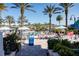 Large community pool with palm trees, lounge chairs, and umbrellas creating a relaxing atmosphere at 2652 Corvette Ln, Kissimmee, FL 34746
