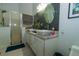 A bathroom showcasing a glass-enclosed shower, white vanity with dual sinks, and textured accent wall at 2822 Moultrie Creek Dr, Kissimmee, FL 34743