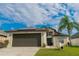 Charming single-Gathering home with a large two-car garage, a palm tree, and solar panels at 2822 Moultrie Creek Dr, Kissimmee, FL 34743