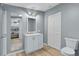 Well lit bathroom with a white vanity, gray walls and a large mirror, and wooden-look floors at 3139 Morning Light Way, Kissimmee, FL 34744