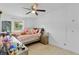 This bedroom includes a ceiling fan, a window, a dresser, and a bed with many pillows at 3139 Morning Light Way, Kissimmee, FL 34744