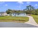 A quaint single story house with a long driveway and well-maintained front lawn on a sunny day at 3139 Morning Light Way, Kissimmee, FL 34744