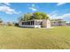 Well-maintained backyard showcasing the home's screened-in lanai, spacious yard, and sunny view at 3260 Osceola Rd, St Cloud, FL 34772