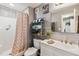 Updated bathroom with patterned shower curtain, and granite countertop at 3260 Osceola Rd, St Cloud, FL 34772