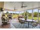 Bright sunroom with wood flooring, ceiling fans, and views of the manicured lawn and outdoor grill at 3260 Osceola Rd, St Cloud, FL 34772