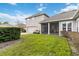 Expansive backyard featuring a screened lanai, lush grass, and a detached garage at 3317 Schoolhouse Rd, Harmony, FL 34773