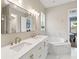 Luxurious bathroom featuring a double vanity, marble countertops, and a soaking tub at 3317 Schoolhouse Rd, Harmony, FL 34773