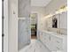 Elegant bathroom with a glass shower, dual sinks, marble accents, and modern lighting at 3317 Schoolhouse Rd, Harmony, FL 34773