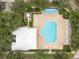 Overhead view of a community pool and lounge area surrounded by lush trees at 3317 Schoolhouse Rd, Harmony, FL 34773