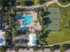 Aerial view of a community pool and tennis courts, surrounded by trees and landscaping at 3317 Schoolhouse Rd, Harmony, FL 34773