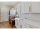 Laundry room features white shaker cabinets, gold hardware, stylish backsplash, and modern washer and dryer set at 3317 Schoolhouse Rd, Harmony, FL 34773