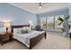 Bright main bedroom featuring a large window, a ceiling fan, and calming blue walls at 3317 Schoolhouse Rd, Harmony, FL 34773