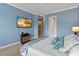Relaxing main bedroom with blue walls, a television, and views of the hallway and ensuite bathroom at 3317 Schoolhouse Rd, Harmony, FL 34773