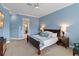 Spacious main bedroom with blue walls, a ceiling fan, and an ensuite bathroom entrance at 3317 Schoolhouse Rd, Harmony, FL 34773