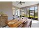 A screened patio with a rustic wooden table, bench, and chairs, offers backyard views for outdoor dining at 3317 Schoolhouse Rd, Harmony, FL 34773