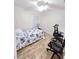 Bright, spacious bedroom features wood-look flooring, a floral comforter, large closet, and rolling desk chair at 334 Sonja Cir, Davenport, FL 33897