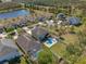 Aerial view of a house with a pool, surrounded by a green backyard and neighboring houses at 3384 Cordgrass Pl, Harmony, FL 34773