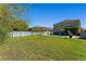 Expansive backyard featuring lush green lawn, a shimmering pool, white fencing, and the rear of the home at 3384 Cordgrass Pl, Harmony, FL 34773
