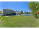 Large backyard with lush green lawn, white fence, pool and the back of the house at 3384 Cordgrass Pl, Harmony, FL 34773
