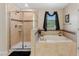 Bright bathroom with a soaking tub and shower features tiled walls and floors at 3384 Cordgrass Pl, Harmony, FL 34773