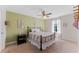Bedroom with neutral carpet, green accent wall, and a ceiling fan at 3384 Cordgrass Pl, Harmony, FL 34773