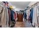 Walk-in closet features custom shelving and a storage system with a wood floor at 3384 Cordgrass Pl, Harmony, FL 34773