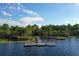 Scenic community boat dock on a tranquil lake, surrounded by lush greenery and providing access for boating at 3384 Cordgrass Pl, Harmony, FL 34773
