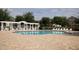 Beautiful community pool with brick patio, white pergola, and ample seating, ideal for relaxation and socializing at 3384 Cordgrass Pl, Harmony, FL 34773