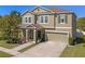 Charming two-story home with a covered porch, attached two-car garage, and a well-manicured lawn at 3384 Cordgrass Pl, Harmony, FL 34773