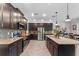Well-equipped kitchen featuring stainless steel appliances, an island with a sink, and dark brown cabinetry at 3384 Cordgrass Pl, Harmony, FL 34773