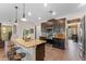 Kitchen view showcasing an island with seating, stainless steel appliances, and modern dark wood cabinets at 3384 Cordgrass Pl, Harmony, FL 34773