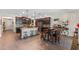 Large kitchen featuring an island with seating, dark cabinetry, and stainless steel appliances, with attached dining area at 3384 Cordgrass Pl, Harmony, FL 34773