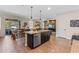 Open-concept kitchen with large island, stainless steel dishwasher, and a view of the outdoor dining area at 3384 Cordgrass Pl, Harmony, FL 34773