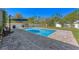 Backyard features a sparkling rectangular pool surrounded by a paved patio and a white fence at 3384 Cordgrass Pl, Harmony, FL 34773