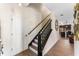 Bright staircase leading upstairs with wood flooring and black handrail at 3384 Cordgrass Pl, Harmony, FL 34773