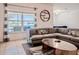 Bright living room features stylish gray sofa, modern decor, and large windows with a serene lake view at 3818 Carrick Bend Dr, Kissimmee, FL 34746
