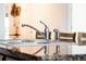 Close up of double sink in a kitchen with granite countertops, a gooseneck faucet and an integrated soap dispenser at 3818 Carrick Bend Dr, Kissimmee, FL 34746