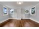 Sunlit bedroom with wood floors, windows, and neutral paint at 415 S 9Th St, Leesburg, FL 34748