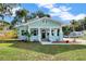 Charming bungalow features a light blue exterior, inviting front porch and neatly manicured landscaping at 415 S 9Th St, Leesburg, FL 34748