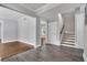 Open-concept living room with hardwood floors, staircase and neutral paint at 415 S 9Th St, Leesburg, FL 34748