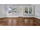 Bright living room with hardwood floors, white trim, and three front windows with ample natural light at 415 S 9Th St, Leesburg, FL 34748