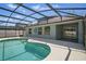 Beautiful backyard pool featuring a screened enclosure and spacious patio area for entertaining and relaxation at 4411 Great Harbor Ln, Kissimmee, FL 34746